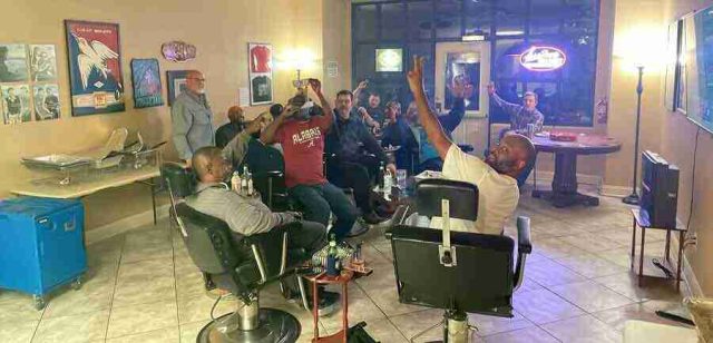 membership-lounge - 11 A group of patrons relaxing, talking, and smoking cigars in comfortable leather chairs inside the dimly lit lounge at F&M Cigars.