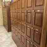 Rows of numbered, premium wooden humidified cigar lockers with brass nameplates and locks in the private member locker area at F&M Cigars.