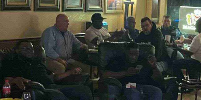 membership-lounge - 9 A group of patrons relaxing, talking, and smoking cigars in comfortable leather chairs inside the dimly lit lounge at F&M Cigars.