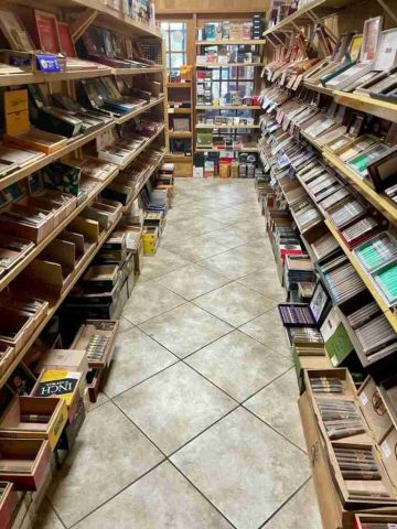 walk-in-humidor - 11 Inside the walk-in humidor at F&M Cigars, featuring fully stocked wooden shelves displaying an extensive selection of premium boutique and classic cigar brands.