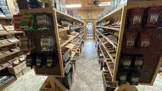 walk-in-humidor - 13 Inside the walk-in humidor at F&M Cigars, featuring fully stocked wooden shelves displaying an extensive selection of premium boutique and classic cigar brands.