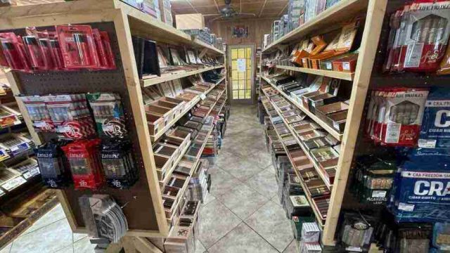 walk-in-humidor - 4 Inside the walk-in humidor at F&M Cigars, featuring fully stocked wooden shelves displaying an extensive selection of premium boutique and classic cigar brands.