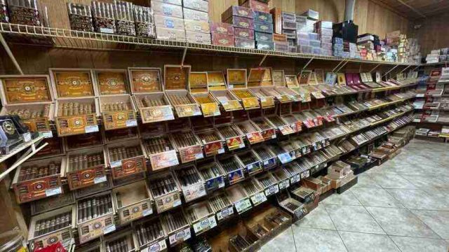 walk-in-humidor - 5 Inside the walk-in humidor at F&M Cigars, featuring fully stocked wooden shelves displaying an extensive selection of premium boutique and classic cigar brands.