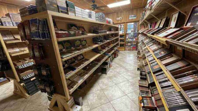 walk-in-humidor - 6 Inside the walk-in humidor at F&M Cigars, featuring fully stocked wooden shelves displaying an extensive selection of premium boutique and classic cigar brands.